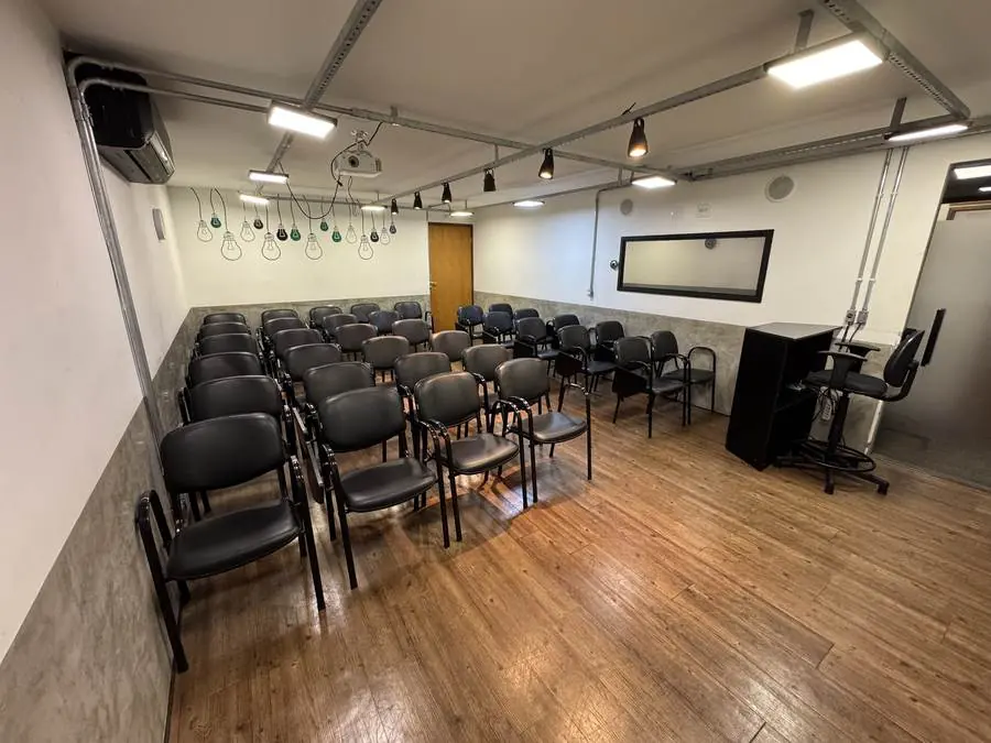 Mesa de apoio para o palestrante no auditório do Espaço Certo, com parede decorada ao fundo