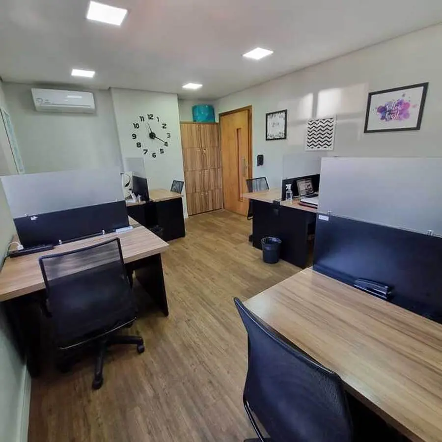 Outra área de coworking, com estações equipadas e armários