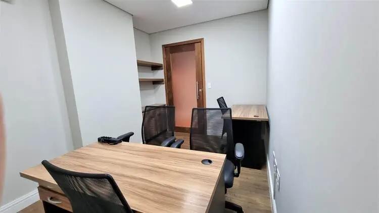 Sala privativa individual com mesa de madeira e armário planejado