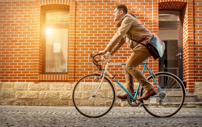 homem indo trabalhar de bicicleta para mostrar como sustentabilidade pode gerar economia nos negócios.