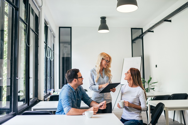 Equipe de trabalho reunida em um escritório, para demonstrar se é melhor escolher uma sala privativa ou coworking compartilhado.