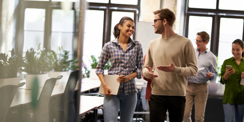 Como melhorar a oratória: grupo de colaboradores caminhando e conversando no coworking.