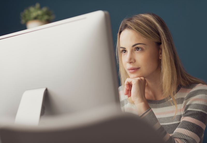 Contabilidade digital: mulher atenta lendo algo no computador.