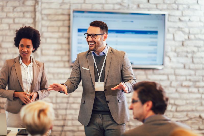 Eventos corporativos​: palestrante apresentando para colegas em auditório de coworking.